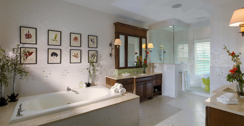 Photo of a large tropical master bathroom in Tampa with raised-panel cabinets, dark wood cabinets, a drop-in tub, a corner shower, white tile, porcelain tile, beige walls, porcelain floors, an undermount sink, marble benchtops, beige floor and an open shower.