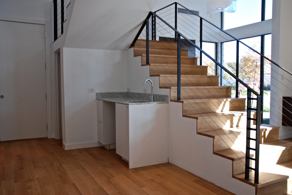 This is an example of a large modern wood staircase in Dallas with wood risers and cable railing.