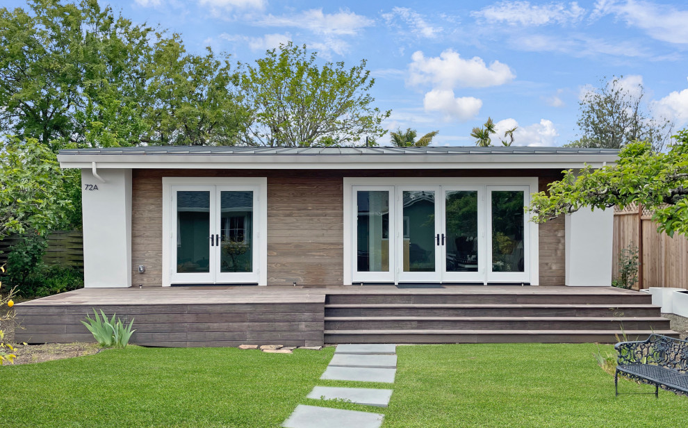 Kleines, Einstöckiges Modernes Tiny House mit Putzfassade, grauer Fassadenfarbe, Pultdach, Blechdach und grauem Dach