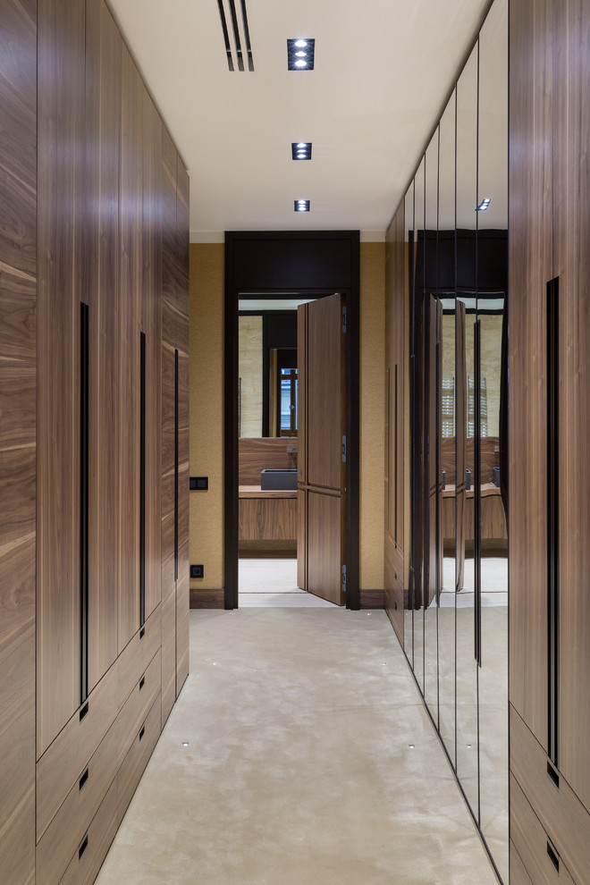 Inspiration for a large contemporary gender-neutral walk-in wardrobe in Moscow with flat-panel cabinets, medium wood cabinets, carpet and beige floor.