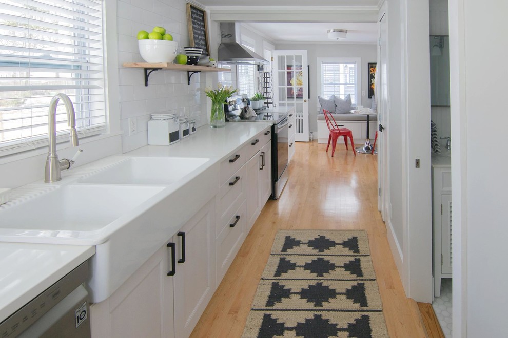 Small transitional single-wall eat-in kitchen in Boston with a double-bowl sink, shaker cabinets, white cabinets, white splashback, stainless steel appliances, no island and white benchtop.