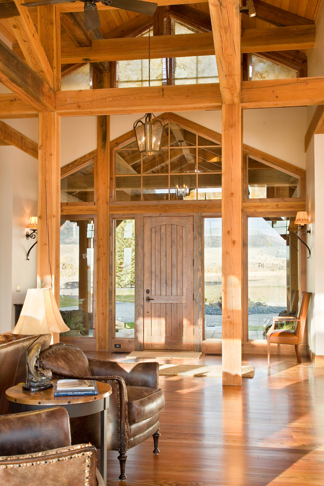 Example of a mid-sized mountain style light wood floor foyer design with white walls and a medium wood front door