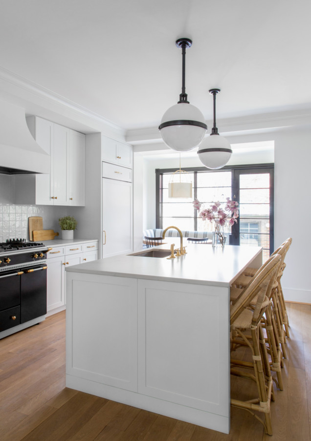 Example of a mid-sized transitional single-wall medium tone wood floor and brown floor eat-in kitchen design in Baltimore with white cabinets, white backsplash, an island, an undermount sink, ceramic backsplash, colored appliances, shaker cabinets, quartz countertops and white countertops