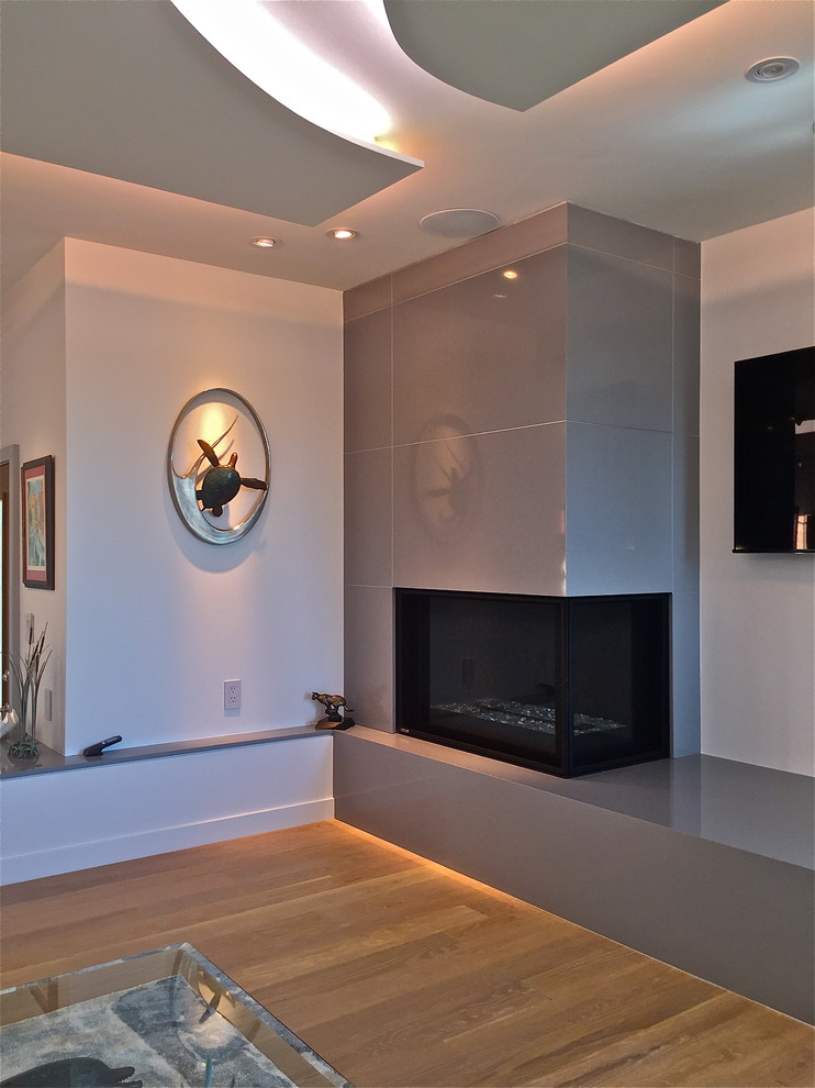 Photo of an expansive modern formal open concept living room in San Luis Obispo with beige walls, medium hardwood floors, a corner fireplace, a stone fireplace surround and a wall-mounted tv.