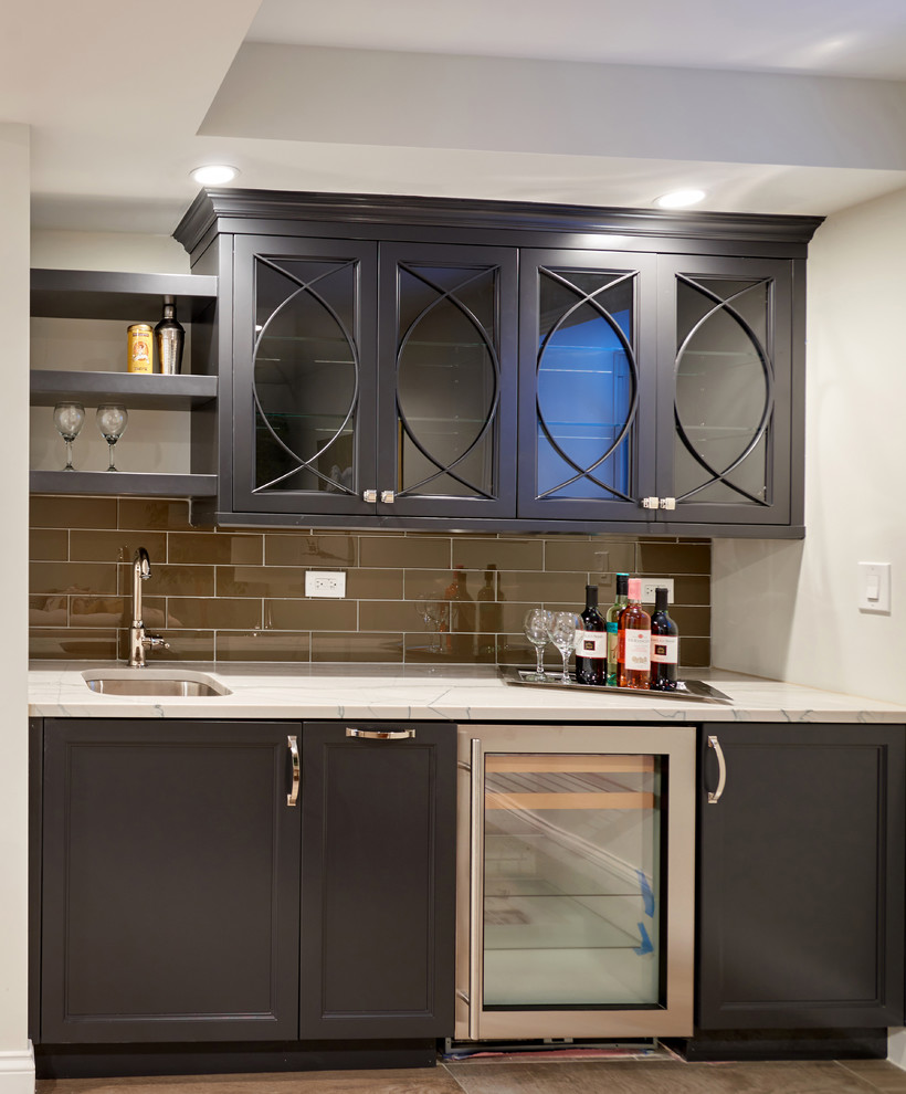 Photo of a small transitional single-wall wet bar in Chicago with an undermount sink, recessed-panel cabinets, grey cabinets, granite benchtops, grey splashback, glass tile splashback and porcelain floors.