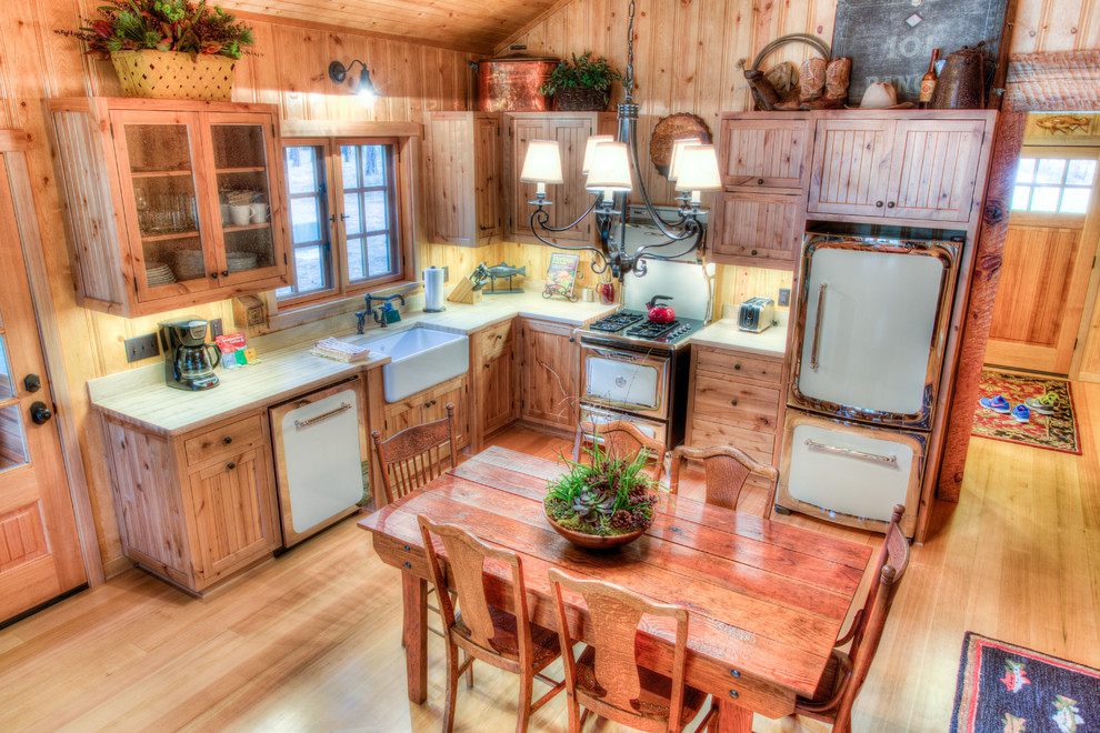 Mid-sized mountain style l-shaped light wood floor eat-in kitchen photo with a farmhouse sink, beaded inset cabinets, light wood cabinets, wood countertops, stainless steel appliances and no island