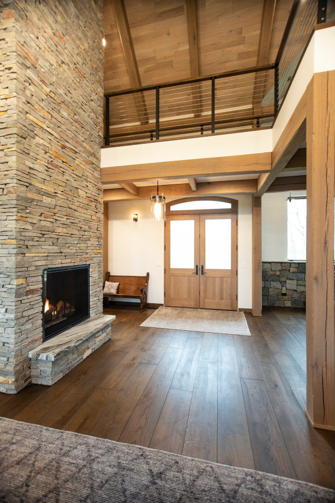 Inspiration for a large rustic medium tone wood floor and exposed beam double front door remodel with white walls and a light wood front door