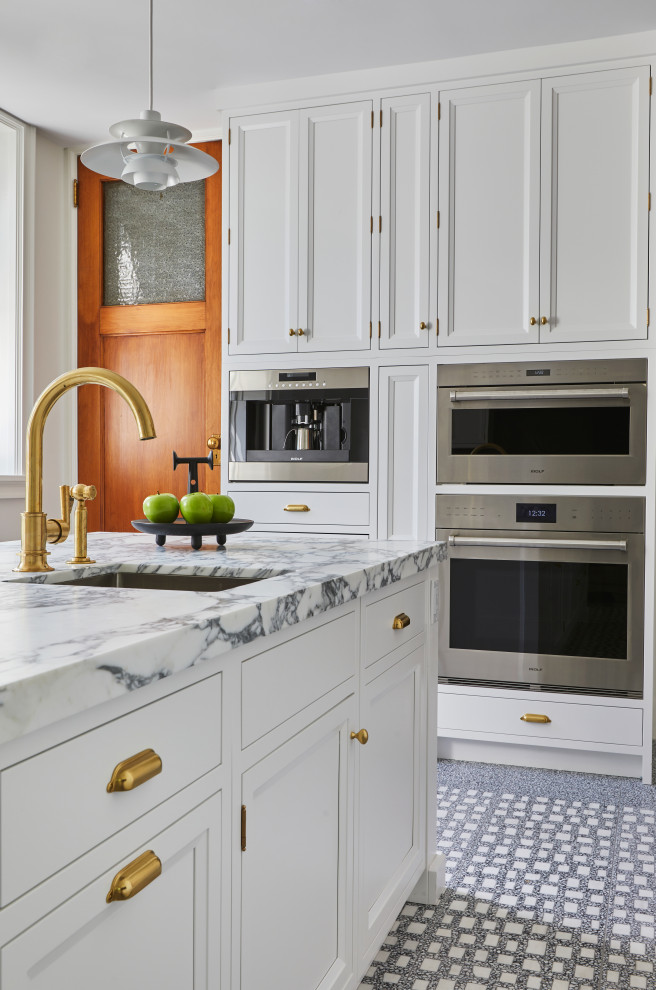 Foto på ett mycket stort vintage grå kök, med en undermonterad diskho, luckor med infälld panel, vita skåp, granitbänkskiva, flerfärgad stänkskydd, stänkskydd i sten, integrerade vitvaror, marmorgolv, en köksö och flerfärgat golv