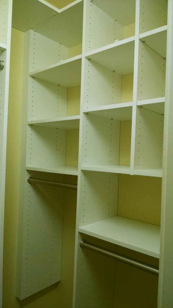 This is an example of a small women's walk-in wardrobe in Other with white cabinets.