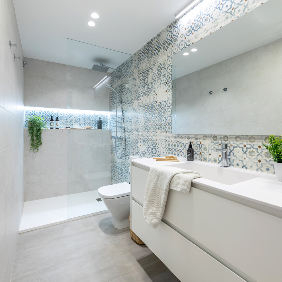 This is an example of a mid-sized modern master wet room bathroom in Barcelona with flat-panel cabinets, white cabinets, multi-coloured tile, ceramic tile, beige walls, ceramic floors, an integrated sink, engineered quartz benchtops, beige floor, white benchtops, a niche, a single vanity and a floating vanity.