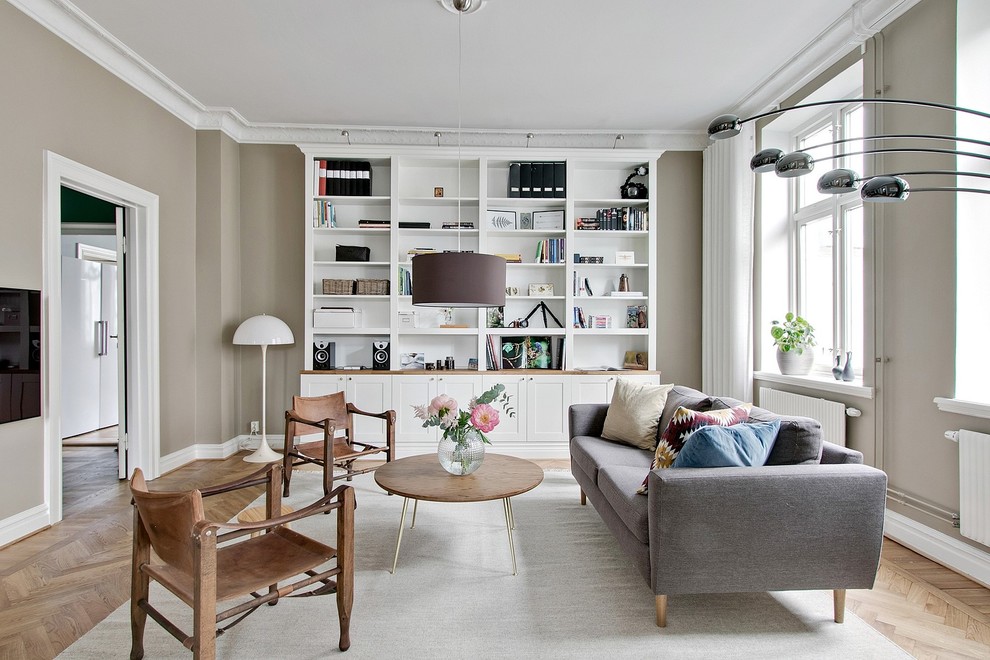 This is an example of a scandinavian formal enclosed living room in Other with grey walls, medium hardwood floors, a wall-mounted tv and beige floor.