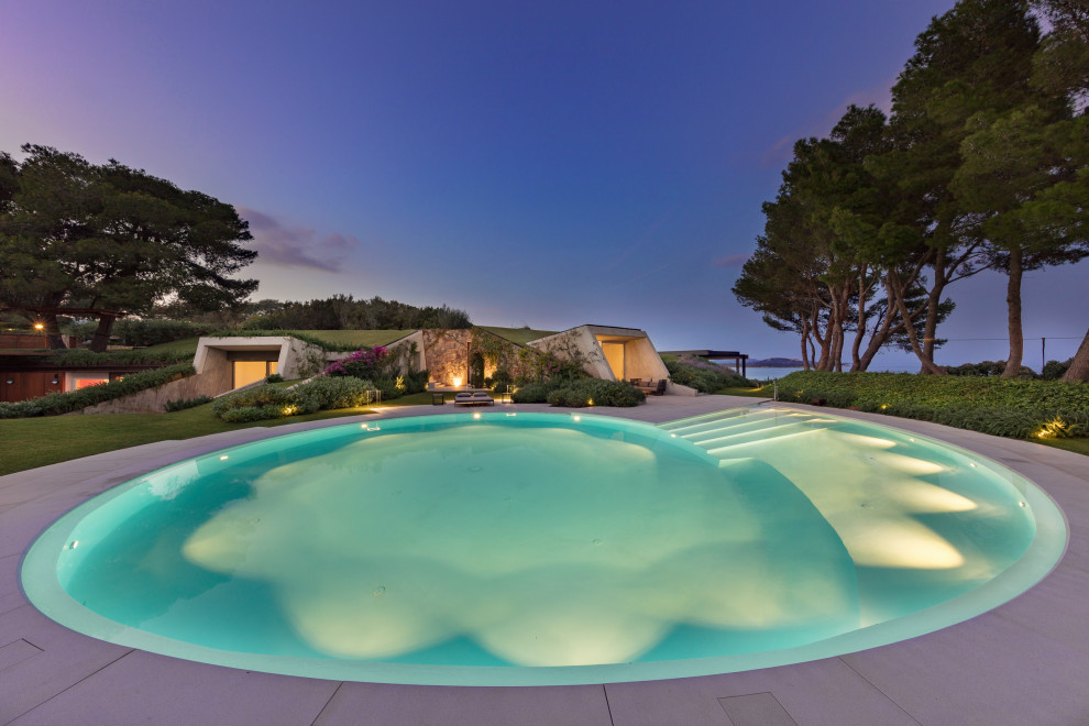 Inspiration for an expansive modern front yard custom-shaped pool in Cagliari with with a pool and natural stone pavers.