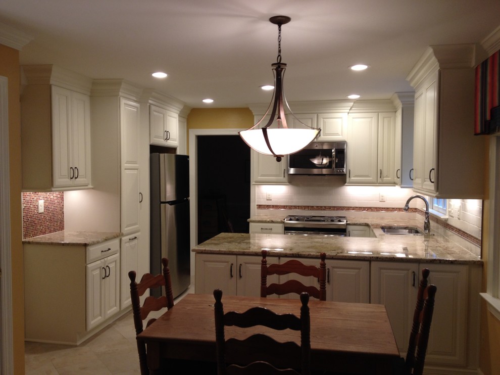 Eat-in kitchen - mid-sized transitional u-shaped ceramic tile eat-in kitchen idea in Richmond with an undermount sink, raised-panel cabinets, white cabinets, granite countertops, white backsplash, subway tile backsplash, stainless steel appliances and a peninsula