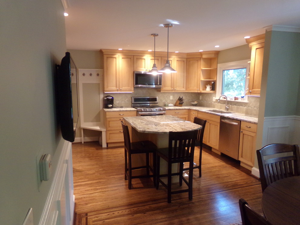Inspiration for a mid-sized transitional l-shaped medium tone wood floor eat-in kitchen remodel in New York with an undermount sink, raised-panel cabinets, light wood cabinets, granite countertops, beige backsplash, subway tile backsplash, stainless steel appliances and an island