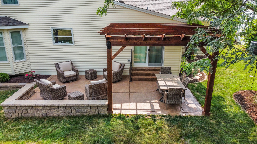 Inspiration for a small backyard patio in St Louis with stamped concrete and a pergola.