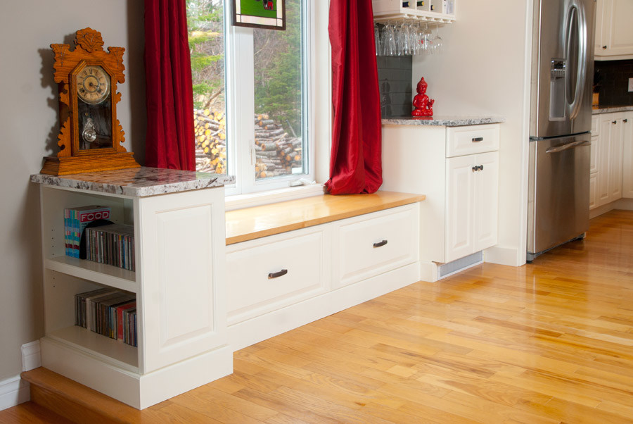 Example of a mid-sized transitional l-shaped light wood floor eat-in kitchen design with an undermount sink, raised-panel cabinets, white cabinets, granite countertops, gray backsplash, glass tile backsplash, stainless steel appliances and an island