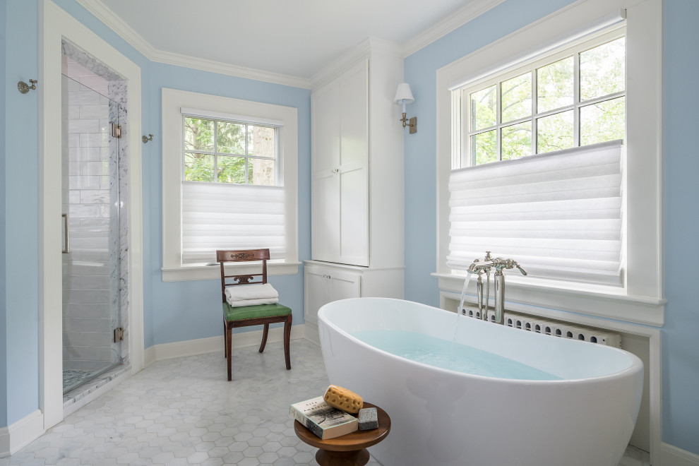 Cette image montre une salle de bain traditionnelle avec une baignoire indépendante, un mur bleu, un sol en carrelage de terre cuite, un sol blanc et boiseries.