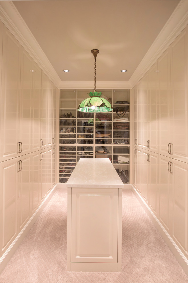 Inspiration for a large traditional gender-neutral walk-in wardrobe in Omaha with raised-panel cabinets, white cabinets, carpet and beige floor.