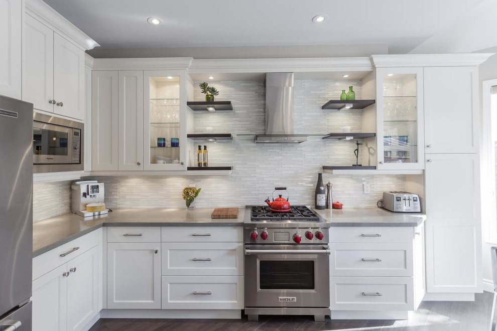 Inspiration for a contemporary l-shaped eat-in kitchen in San Francisco with shaker cabinets, white cabinets, quartz benchtops, white splashback, matchstick tile splashback, stainless steel appliances, medium hardwood floors, no island and grey floor.