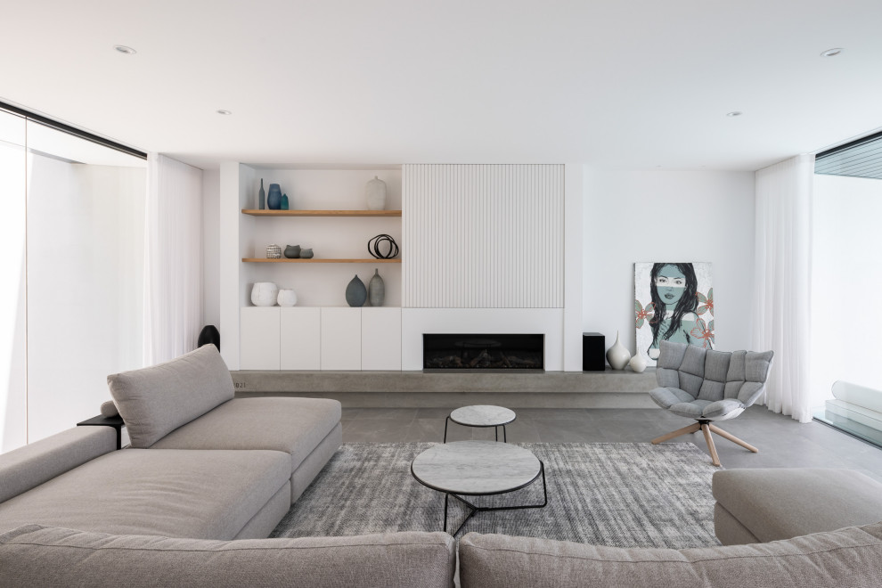 シドニーにあるラグジュアリーな広いコンテンポラリースタイルのおしゃれなLDK (白い壁、磁器タイルの床、標準型暖炉、漆喰の暖炉まわり、内蔵型テレビ、グレーの床) の写真