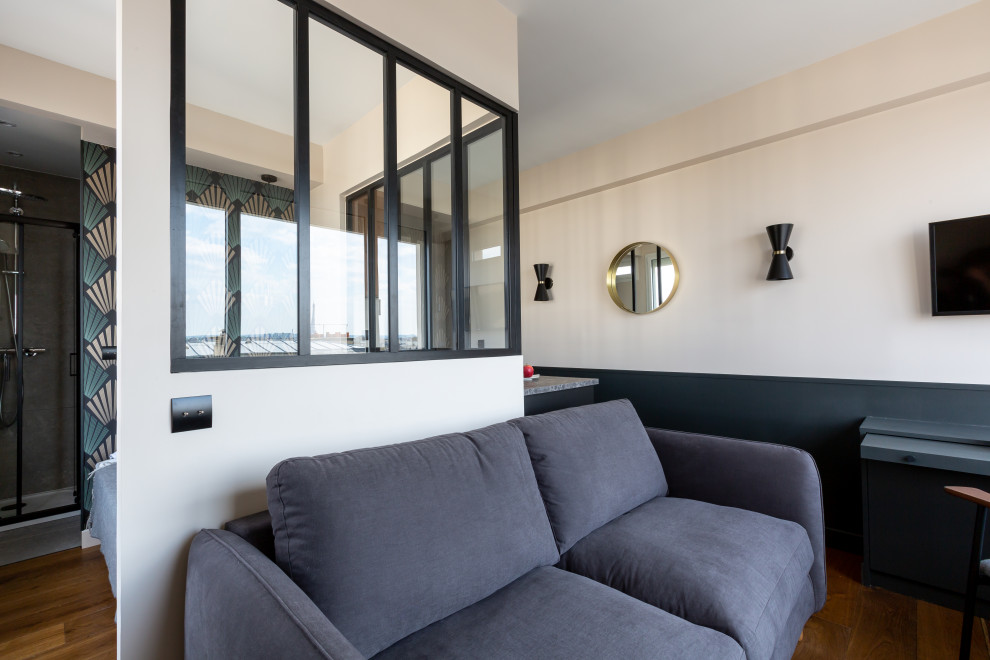 Esempio di un piccolo soggiorno minimal aperto con pareti nere, pavimento in legno massello medio, nessun camino, TV a parete e pavimento marrone