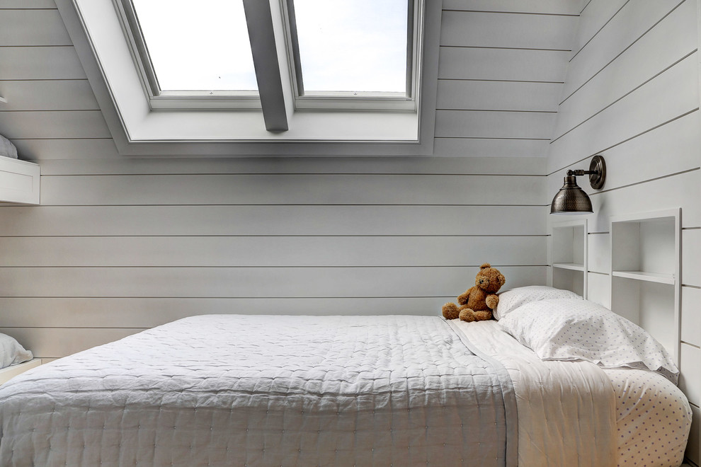 This is an example of a mid-sized country gender-neutral kids' bedroom for kids 4-10 years old in New York with white walls, light hardwood floors and beige floor.