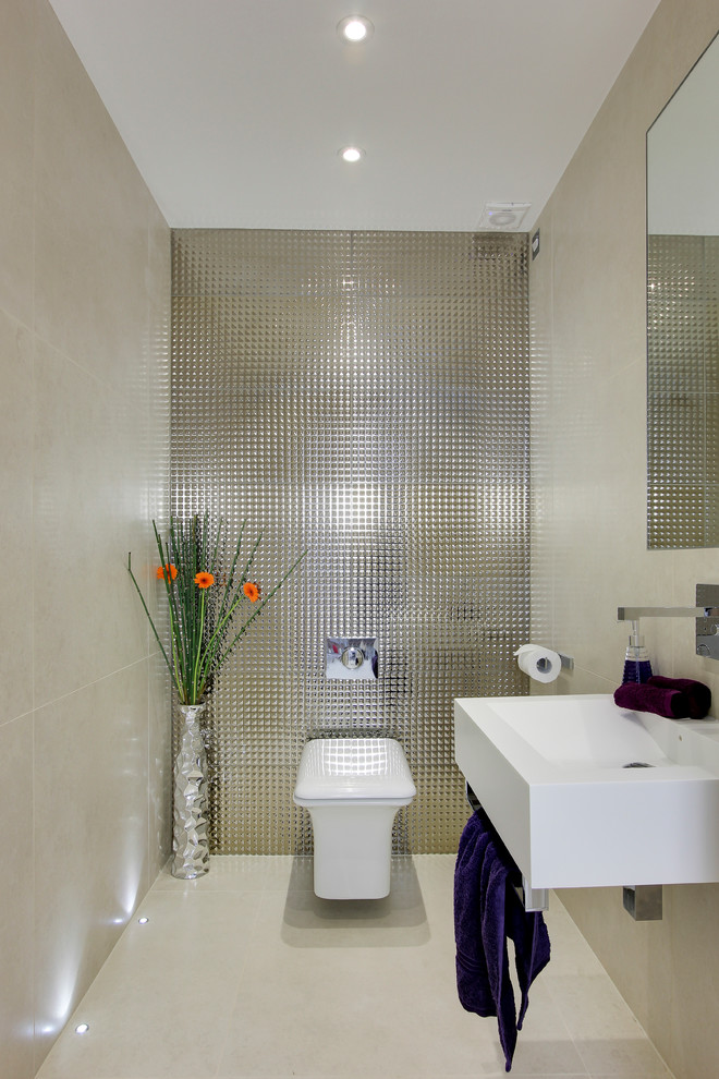 Photo of a small contemporary powder room in Hertfordshire with a wall-mount sink, a wall-mount toilet, porcelain floors and metal tile.