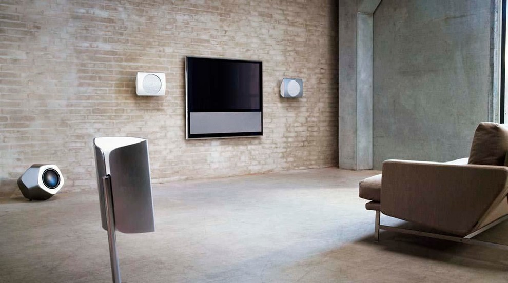 This is an example of an industrial living room in Sydney with beige walls, concrete floors and a wall-mounted tv.