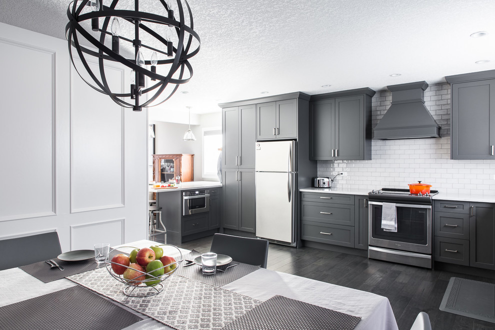 Inspiration for a large contemporary l-shaped eat-in kitchen in Calgary with an undermount sink, shaker cabinets, grey cabinets, marble benchtops, yellow splashback, subway tile splashback, stainless steel appliances, dark hardwood floors and a peninsula.