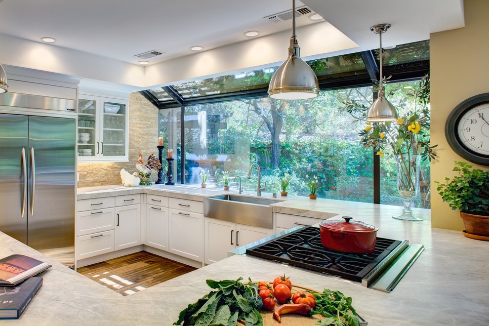Large contemporary l-shaped eat-in kitchen in Sacramento with an undermount sink, recessed-panel cabinets, white cabinets, marble benchtops, beige splashback, cement tile splashback, stainless steel appliances, medium hardwood floors and a peninsula.