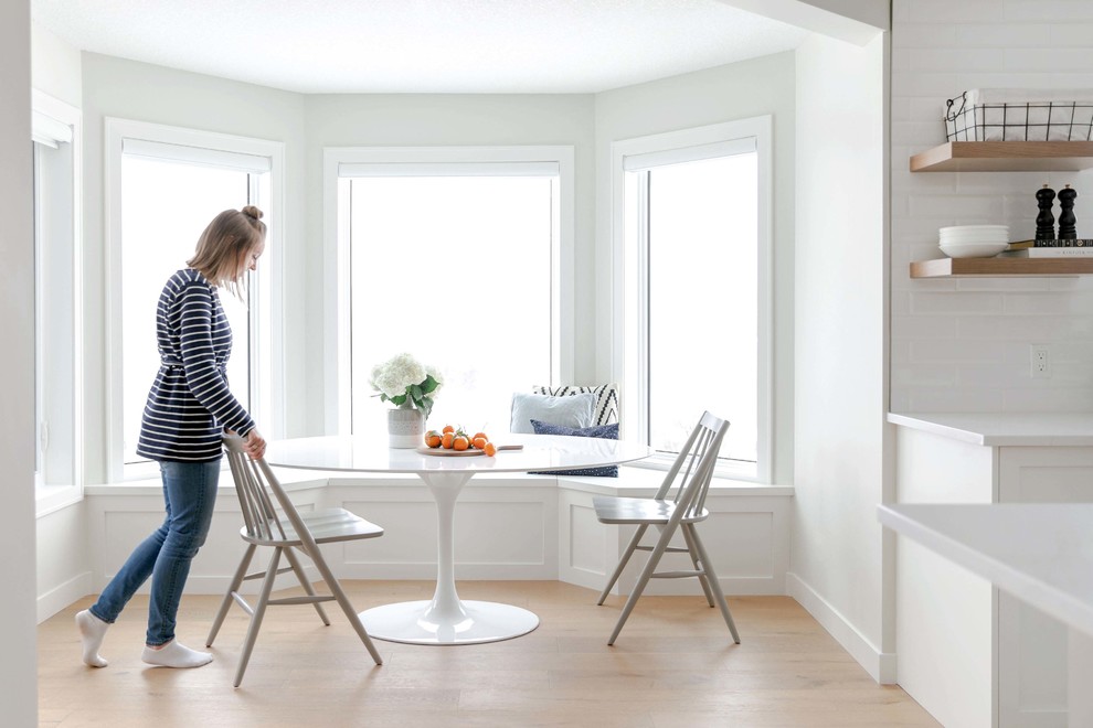Inspiration for a large transitional u-shaped medium tone wood floor and brown floor eat-in kitchen remodel in Calgary with an undermount sink, shaker cabinets, white cabinets, quartzite countertops, white backsplash, subway tile backsplash, stainless steel appliances, an island and white countertops