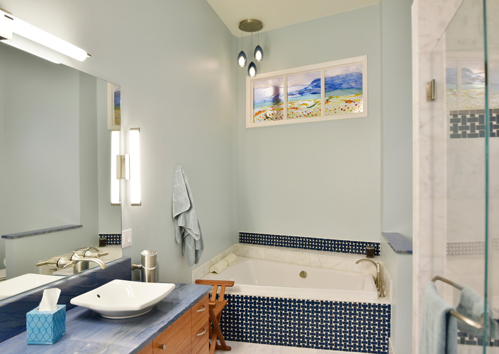 Design ideas for a large midcentury master bathroom in Albuquerque with a vessel sink, flat-panel cabinets, medium wood cabinets, granite benchtops, a corner tub, an alcove shower, a one-piece toilet, blue tile, glass tile, blue walls and light hardwood floors.