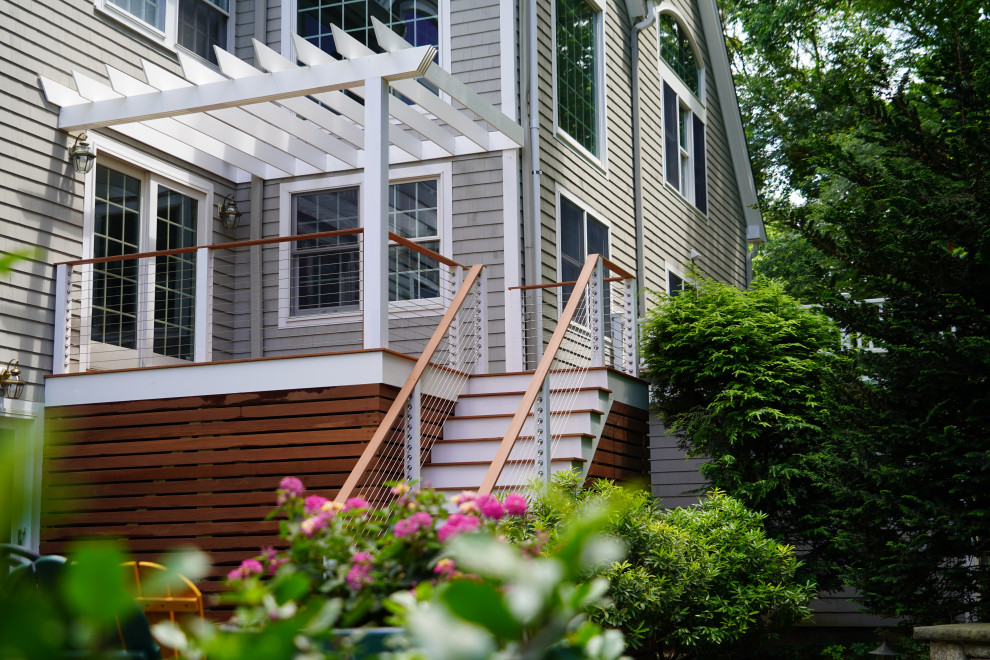 This is an example of a medium sized contemporary side ground level wire cable railing terrace in Boston with an outdoor kitchen and a pergola.