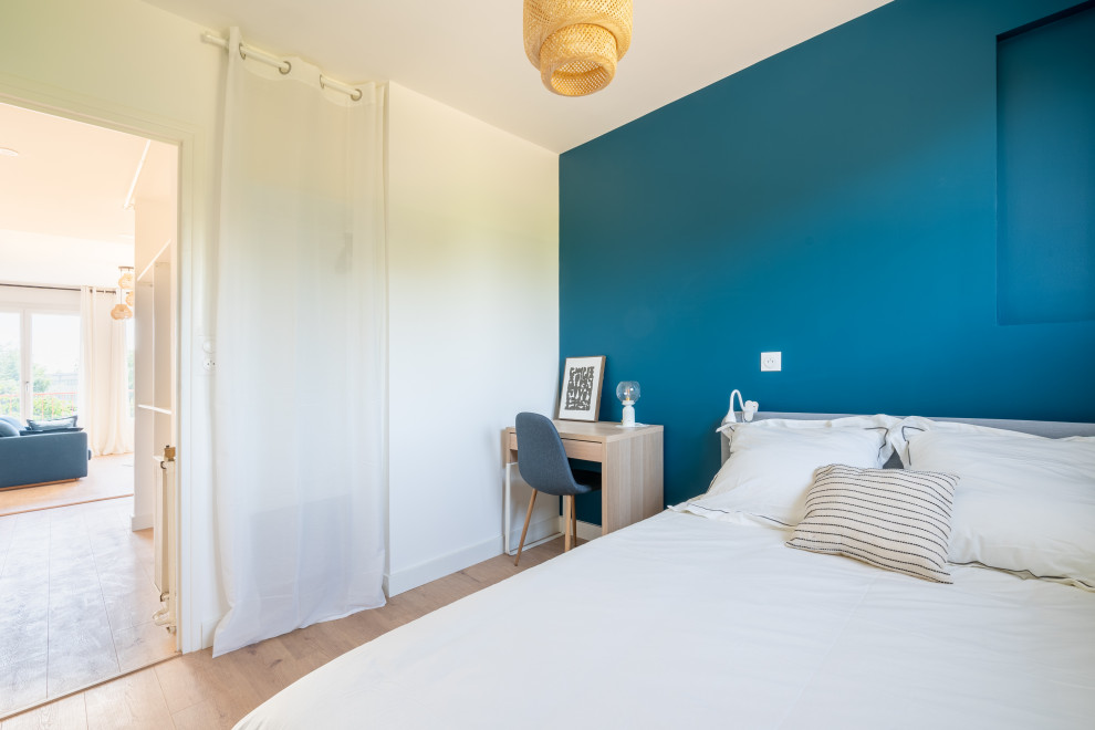 Idées déco pour une petite chambre d'amis blanche et bois contemporaine avec un mur bleu, parquet clair, aucune cheminée, un sol beige et dressing.