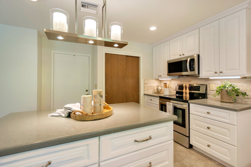 Inspiration for a large transitional l-shaped porcelain tile open concept kitchen remodel in Phoenix with an undermount sink, raised-panel cabinets, white cabinets, quartz countertops, beige backsplash, porcelain backsplash, stainless steel appliances and an island
