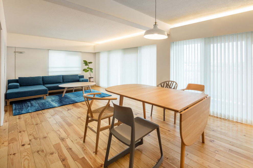 Photo of a large modern open plan dining in Yokohama with white walls, medium hardwood floors, no fireplace, beige floor, exposed beam and planked wall panelling.