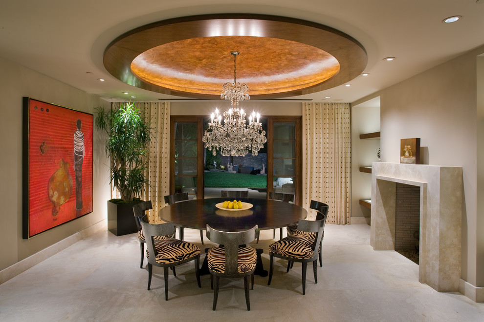 This is an example of a large contemporary separate dining room in Orange County with a concrete fireplace surround, concrete floors, white walls, a standard fireplace and beige floor.