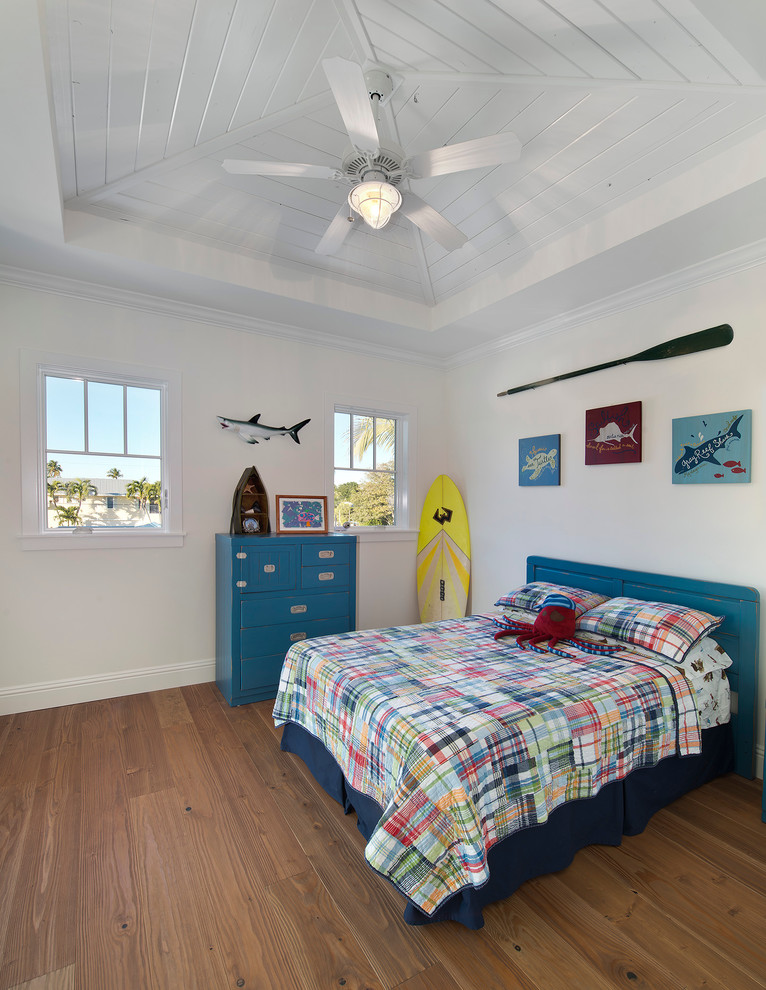 Design ideas for a tropical kids' bedroom for kids 4-10 years old and boys in Miami with white walls and medium hardwood floors.