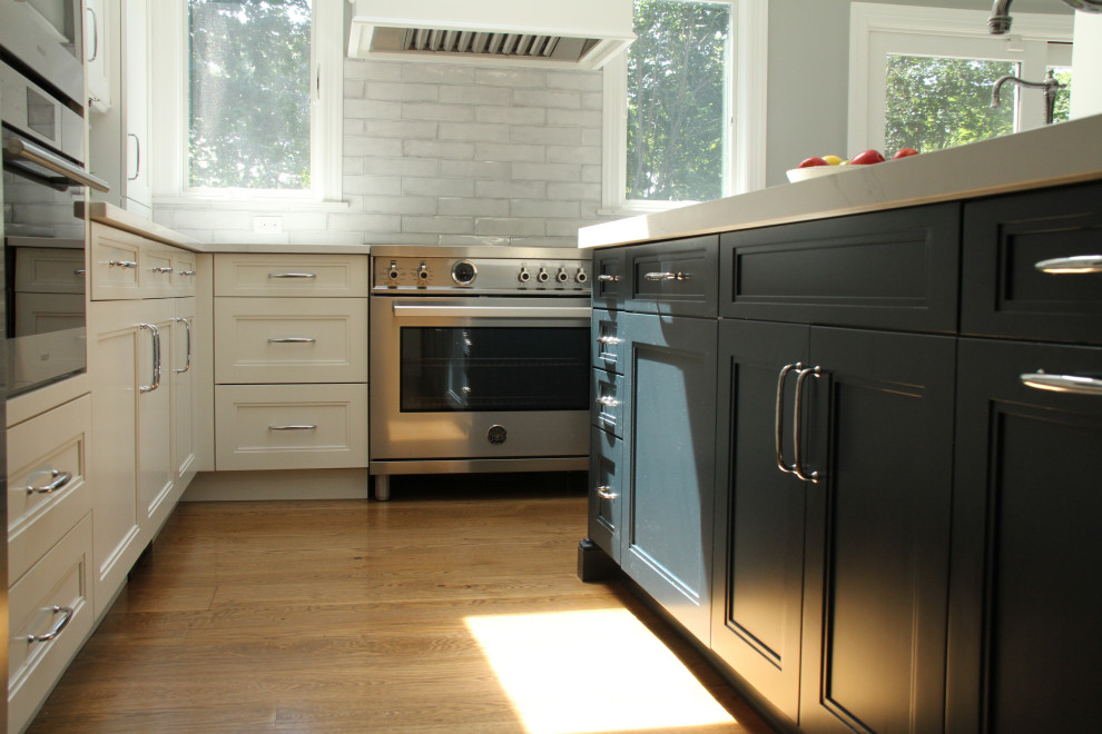 Inredning av ett modernt mellanstort vit vitt kök, med en undermonterad diskho, vita skåp, bänkskiva i kvarts, vitt stänkskydd, stänkskydd i keramik, rostfria vitvaror, ljust trägolv, en köksö och brunt golv