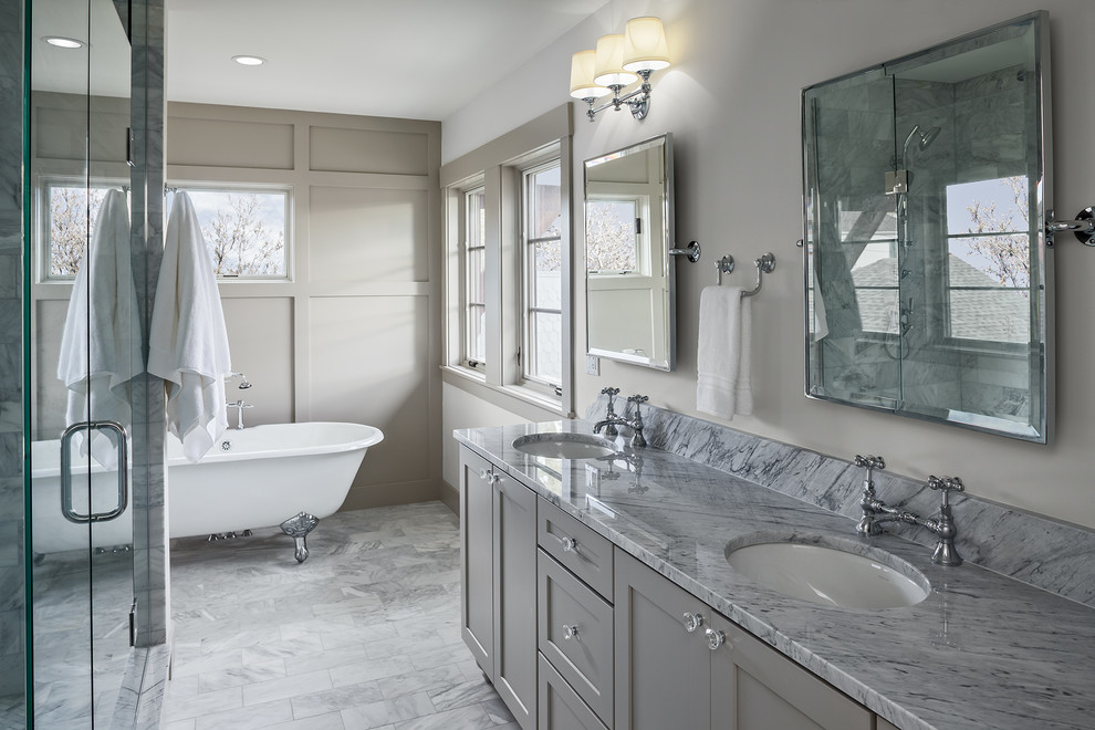 This is an example of a mid-sized transitional master bathroom in Denver with grey cabinets, beige walls, ceramic floors, an undermount sink, marble benchtops, grey floor, a hinged shower door, grey benchtops, a claw-foot tub and shaker cabinets.