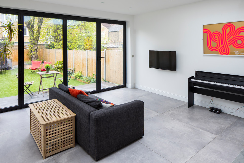 Photo of a large contemporary open concept living room in London with a music area, white walls, porcelain floors, no fireplace, a wall-mounted tv and grey floor.