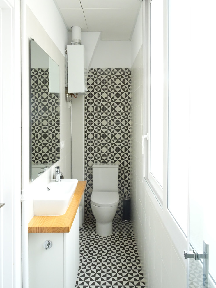 Mid-sized scandinavian powder room in Alicante-Costa Blanca with white cabinets, a one-piece toilet, black and white tile, ceramic tile, ceramic floors, a vessel sink, wood benchtops, flat-panel cabinets, multi-coloured walls and multi-coloured floor.