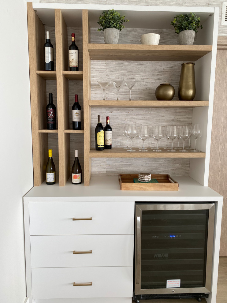 Inspiration for a mid-sized beach style home bar in Miami with an undermount sink, flat-panel cabinets, white cabinets, quartz benchtops, white splashback, engineered quartz splashback, vinyl floors, brown floor and white benchtop.