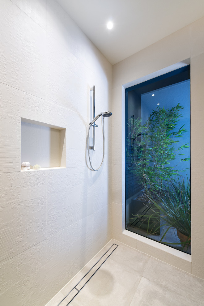 This is an example of a modern master wet room bathroom in Melbourne with flat-panel cabinets, white tile, porcelain tile, white walls, porcelain floors, engineered quartz benchtops, white floor and an open shower.