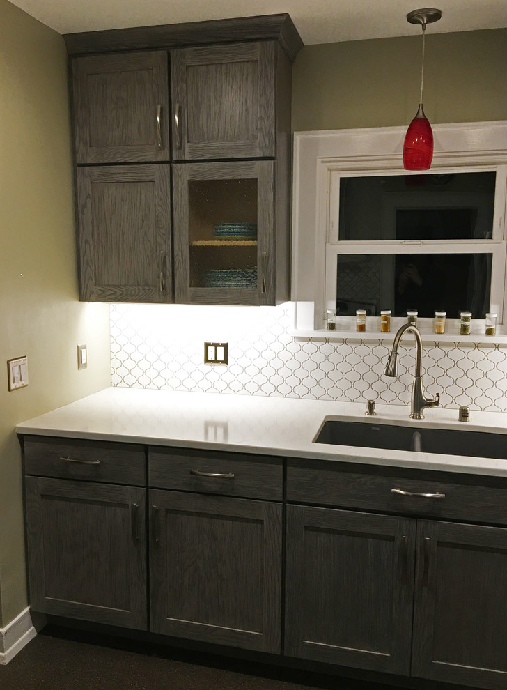 Enclosed kitchen - small transitional galley enclosed kitchen idea in Seattle with an undermount sink, shaker cabinets, gray cabinets, quartzite countertops, white backsplash, ceramic backsplash, stainless steel appliances and no island