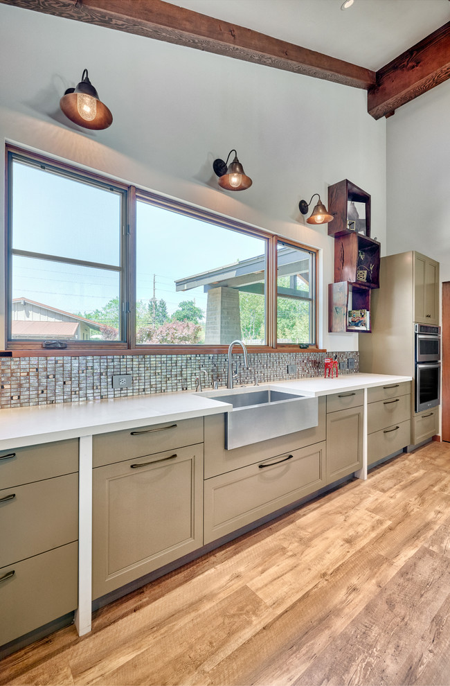 Design ideas for a large country u-shaped open plan kitchen in Sacramento with a farmhouse sink, recessed-panel cabinets, green cabinets, quartz benchtops, metallic splashback, mosaic tile splashback, stainless steel appliances, vinyl floors, with island, brown floor and white benchtop.