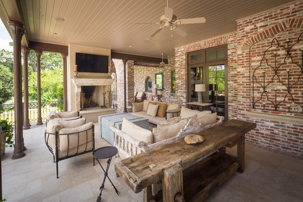Inspiration for a traditional backyard patio in Houston with natural stone pavers, a roof extension and with fireplace.