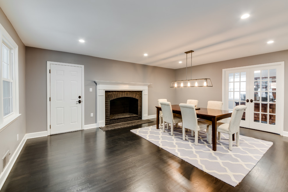 Design ideas for a mid-sized transitional separate dining room in Other with grey walls, dark hardwood floors, a standard fireplace, a brick fireplace surround and black floor.