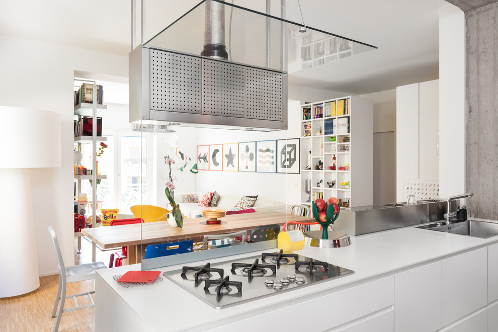 Design ideas for an eclectic galley eat-in kitchen in Rome with flat-panel cabinets, white cabinets, marble benchtops, black splashback, white appliances, with island and grey benchtop.