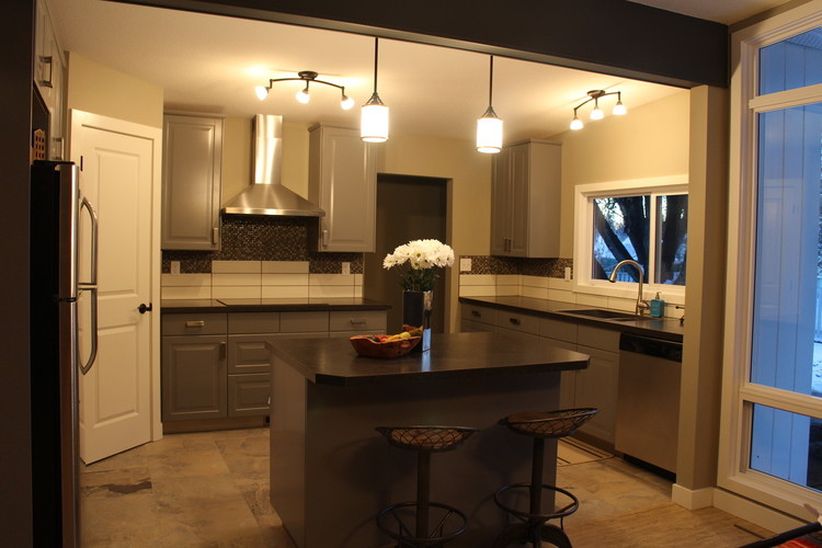 This is an example of a mid-sized transitional u-shaped open plan kitchen in Calgary with an undermount sink, raised-panel cabinets, grey cabinets, white splashback, porcelain splashback, stainless steel appliances and with island.
